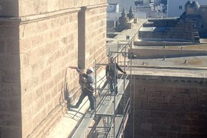 Un operario realizando hace unos días un agujero con taladro en la piedra caliza del campanario.