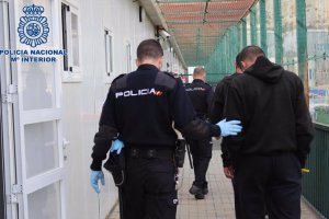 Un agente de Policía Nacional acompaña a un inmigrante en el CATE de Almería.