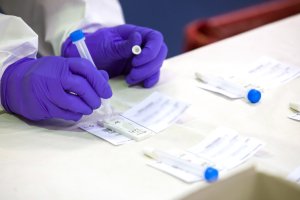 Un trabajador sanitario sostiene una de las probetas utilizadas para realizar un test de antígenos.