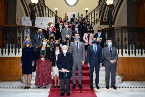 Foto de familia de autoridades y premiados con las banderas de Andalucía