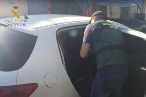 Un agente introduce a un acusado en el coche