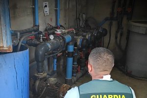 Agente comprobando la maquinaria en el almacén agrícola.