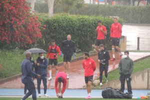 Los jugadores llegando al campo Anexo bajo la lluvia.