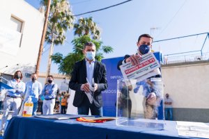 El presidente junto al alcalde introduciendo un periódico para el acto de la primera piedra.
