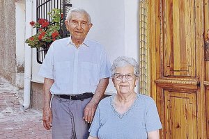 Alonso y su esposa junto a la puerta de madera (de 150 años de historia) de su casa de Albanchez.