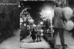 La feria del Parque en el año 1965. Un matrimonio paseando bajo los árboles y las bombillas de color con un par de globos en la mano.