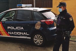 Imagen de archivo de un coche y una agente de Policía Nacional.