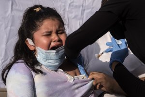 Una niña llora al ser vacunada contra el covid en Los Ángeles (EEUU).
