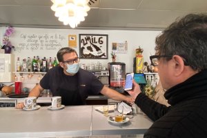 Ramón Quirantes, de la Cafetría 2mil6, pide el pasaporte a un cliente.