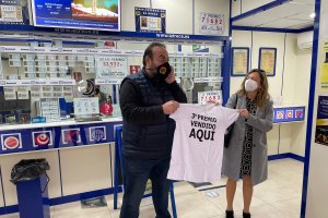 El lotero de la administración que ha repartido la suerte celebra el premio.