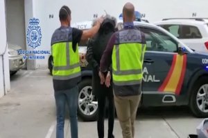 Agentes conduciendo al detenido al coche de la Policía Nacional.
