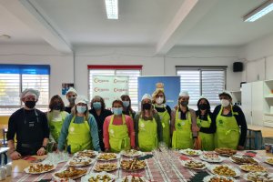 Los asistentes al curso de cocina, junto a los profesores, se fotografían junto a sus platos.