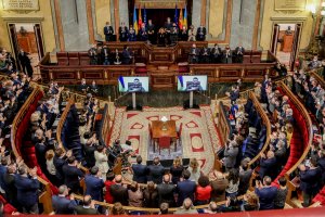 Asistentes aplauden tras la comparecencia telemática del presidente de Ucrania, Volodímir Zelenski, en el hemiciclo del Congreso de los Diputados.