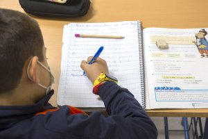 Un niño con mascarilla en clase.
