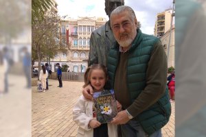 El abogado y escrito Juan Martínez Fernández posa con su nieta y con su novela más reciente.