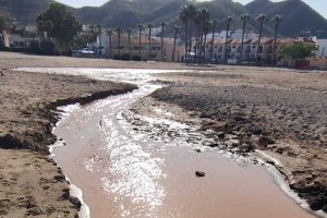 Socavón creado por el caudal de agua de la obra en plena Playa de San José.