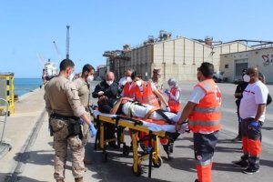 Uno de los supervivientes en camilla a su llegada al puerto.