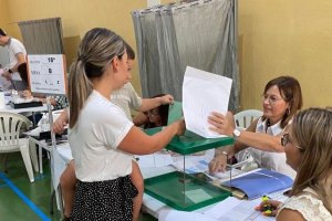 Una mujer acude con su hijo a votar.