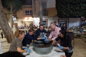 Los voluntarios y el alcalde rellenan cucuruchos de castañas para los vecinos.