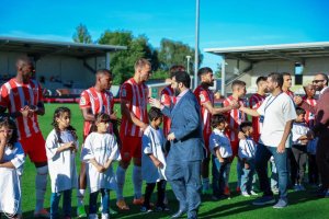 Turki saludando a sus jugadores antes de un amistoso en Inglaterra.