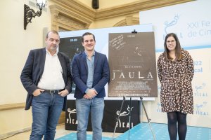 Ignacio Tatay, director de Jaula, con Enrique Iznaola y Almudena Morales frente al póster de su película.