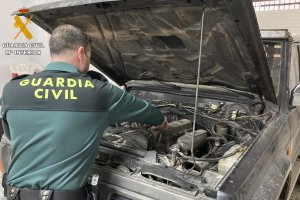 Un guardia civil examina el coche robado en Granada.