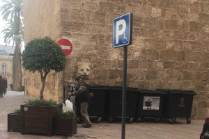 Imagen de la fachada de la torre del campanario de la catedral con los contenedores de basura.