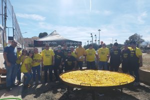 Asistentes junto a la gran paella.
