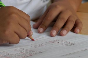 Un alumno realiza sus tareas en el colegio.