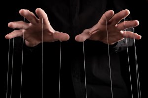 Manos controlando los hilos.