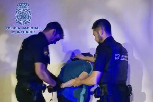 Dos agentes detienen al preso fugado.