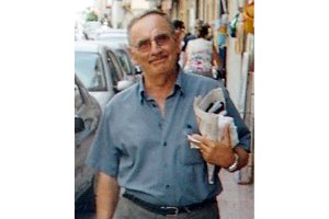 Pedro González, por la calle Mayor de Garrucha, con periódicos en la mano.