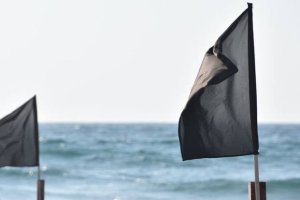 Banderas negras en una playa.