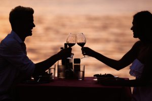 Una pareja brindando frente al mar.