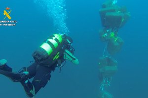 Agente de la Guardia Civil recupera los fardos.