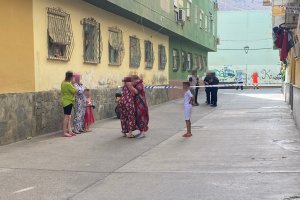 Dos vecinas se abrazan tras conocer el asesinato de una mujer en Pescadería.