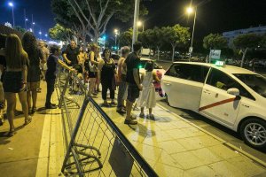 Usuarios guardan cola de manera ordenada para coger un taxi.