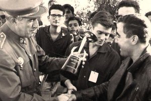 Carlos Escaso recibiendo una copa después de haber ganado una carrera.