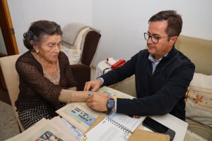 El alcalde haciendo entrega de una pulsera qr a una usuaria de El Ejido.