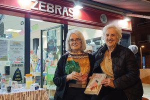 Marie Córdoba y María Jesús Orbegozo a las puertas de la librería Zebras con un ejemplar de \'¡Que viva Frida1\'