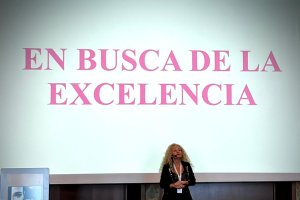 Conchi impartiendo una conferencia con su lema detrás.