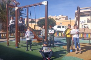 Algunos de los escolares en el parque posando con dibujos que aparecen en el vídeo que han realizado en el CEIP Virgen del Mar de Cabo de Gata. (FO