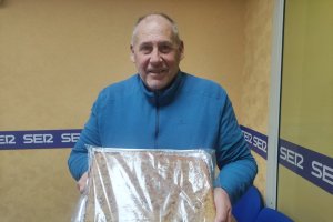 Baldomero Titos posando con una torta de Chicharrones.