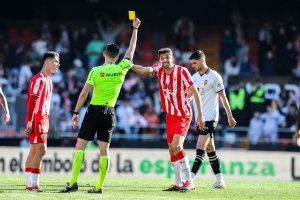 Muñiz Ruiz mostrando cartulina amarilla a Édgar González en la segunda mitad del choque.