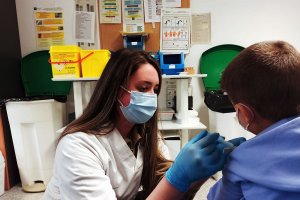 Una enfermera pone una vacuna a un niño. 