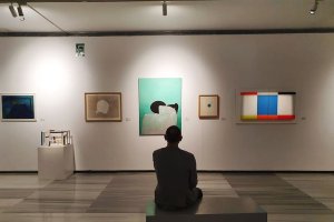 Un visitante observa las obras en la exposición.