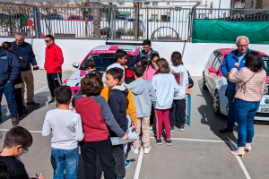 El alumnado haciendo cola para ver los coches de competición de cerca.