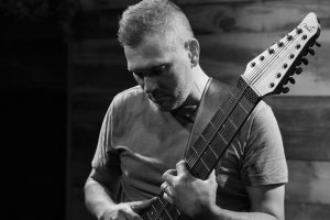 Jason Blake toca su Warr Guitar en una imagen cortesía del músico.