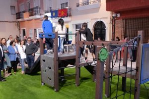 Las autoridades observando el nuevo parque en el que juegan unos niños.