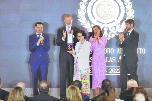 Imagen de la hermana de Guirao recogiendo la medalla y foto de familia.